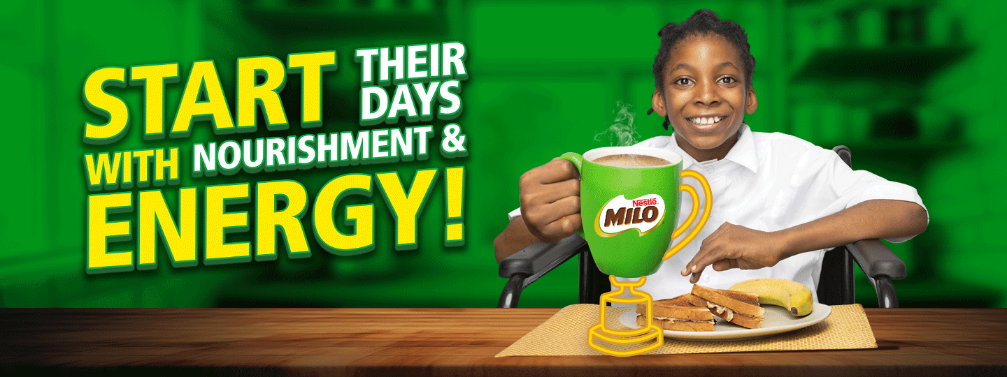Girl sitting on a chair holding a milo mug while eating her breakfast